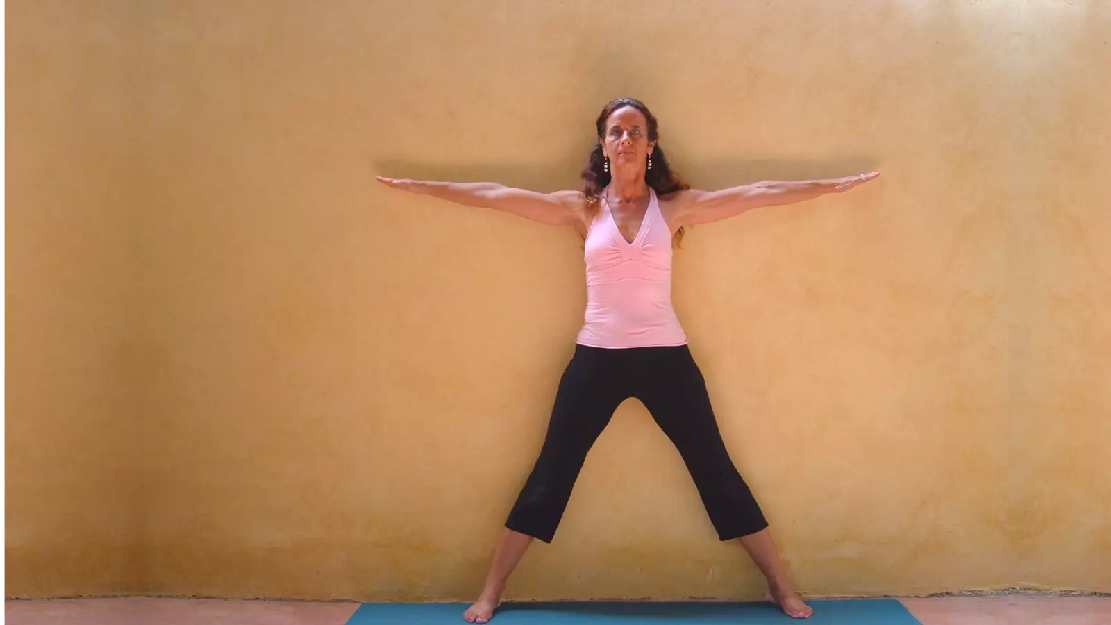 Starting position to practice Half Moon Pose at the wall.