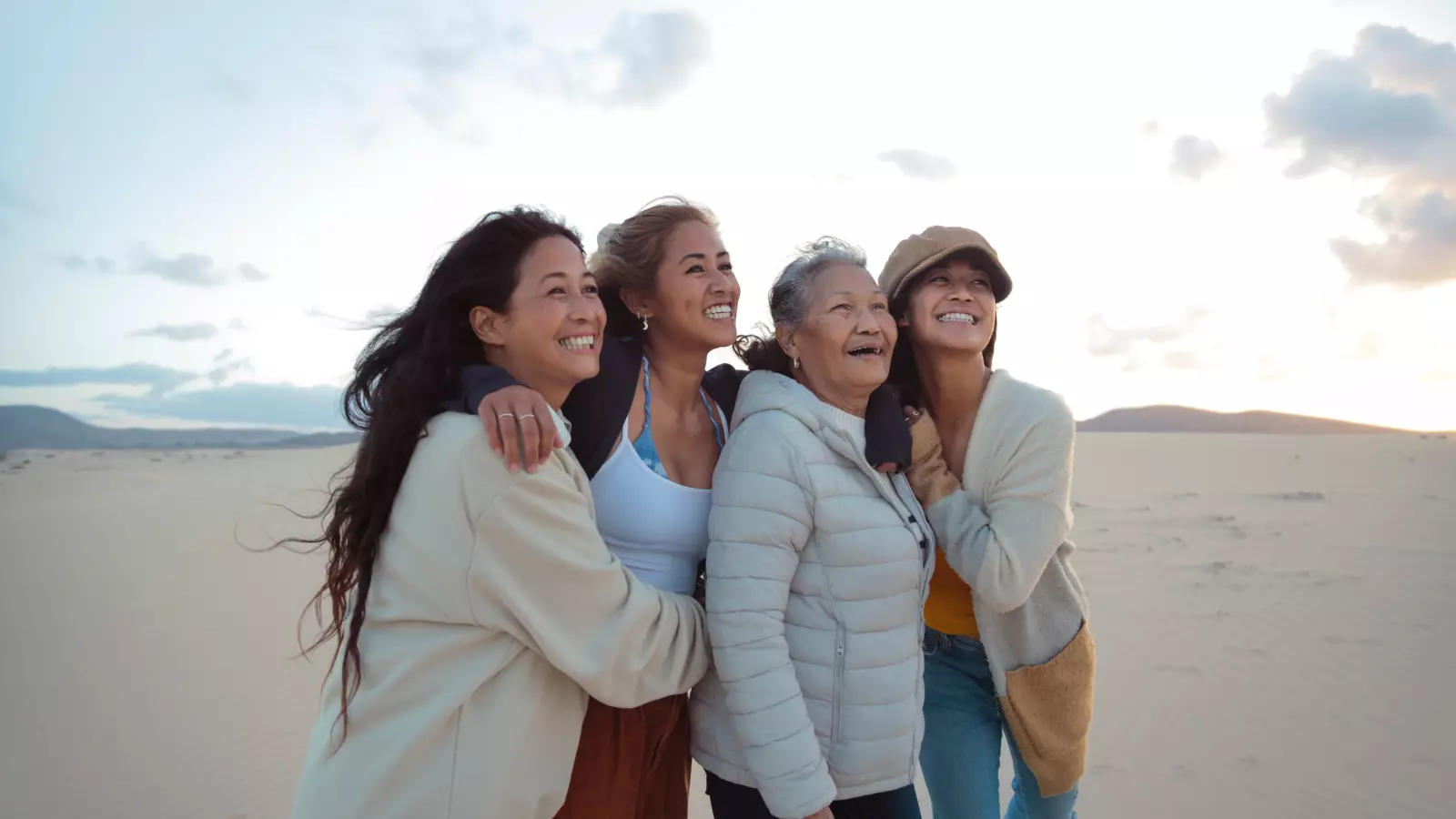 Family of four filipino women walking and hugging each other in a desert land - Beautiful women of different generations spending time together. Concept intergenerational trauma.