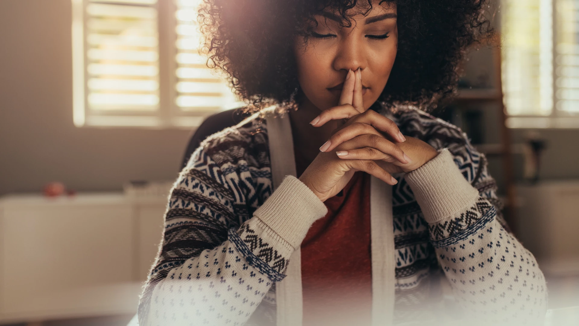 Woman sitting at her work desk and thinking with her eyes closed. Grief, yoga and mindfulness concept.