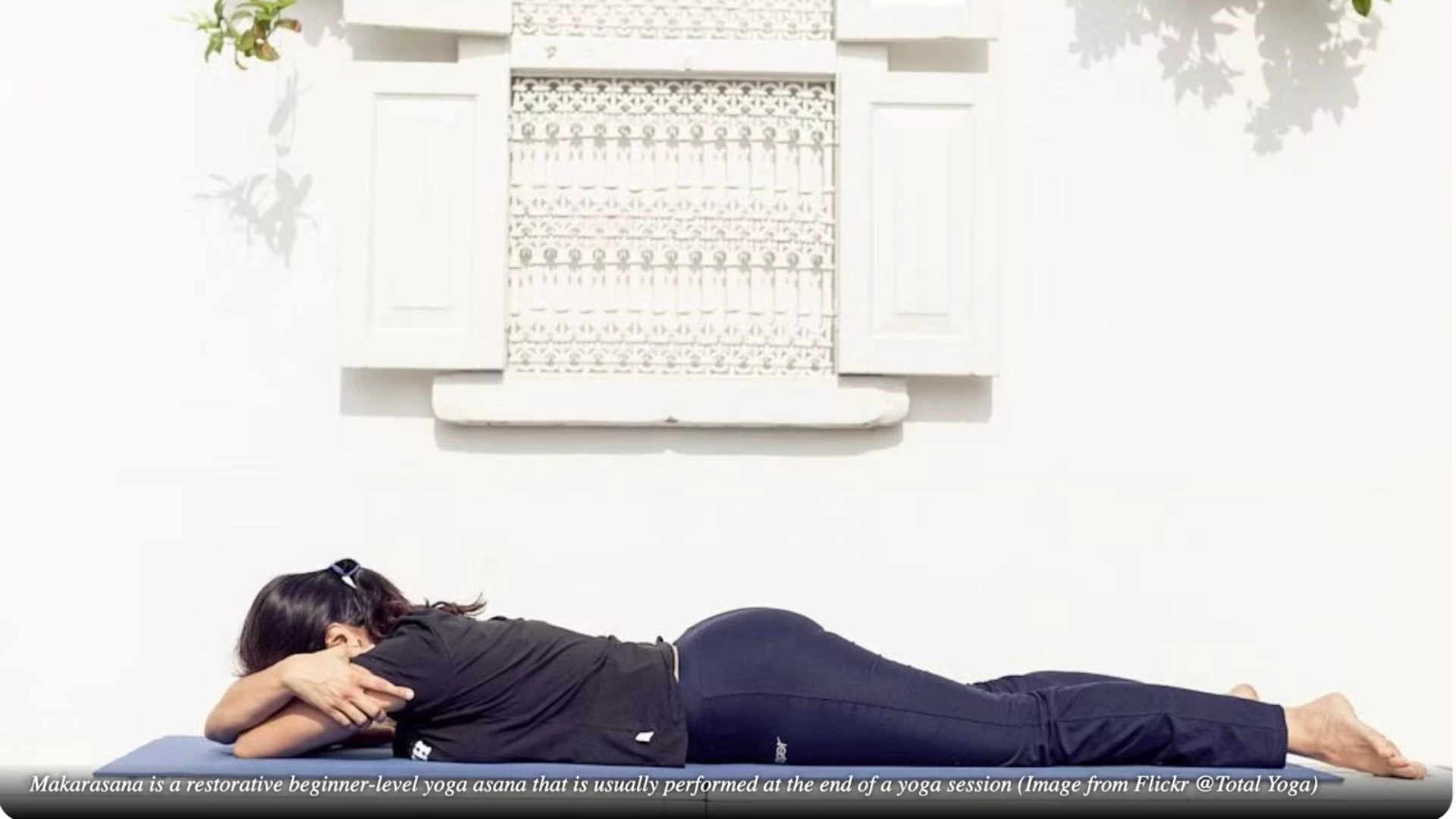 Sporty woman relaxes in yoga asana Makarasana - crocodile pose