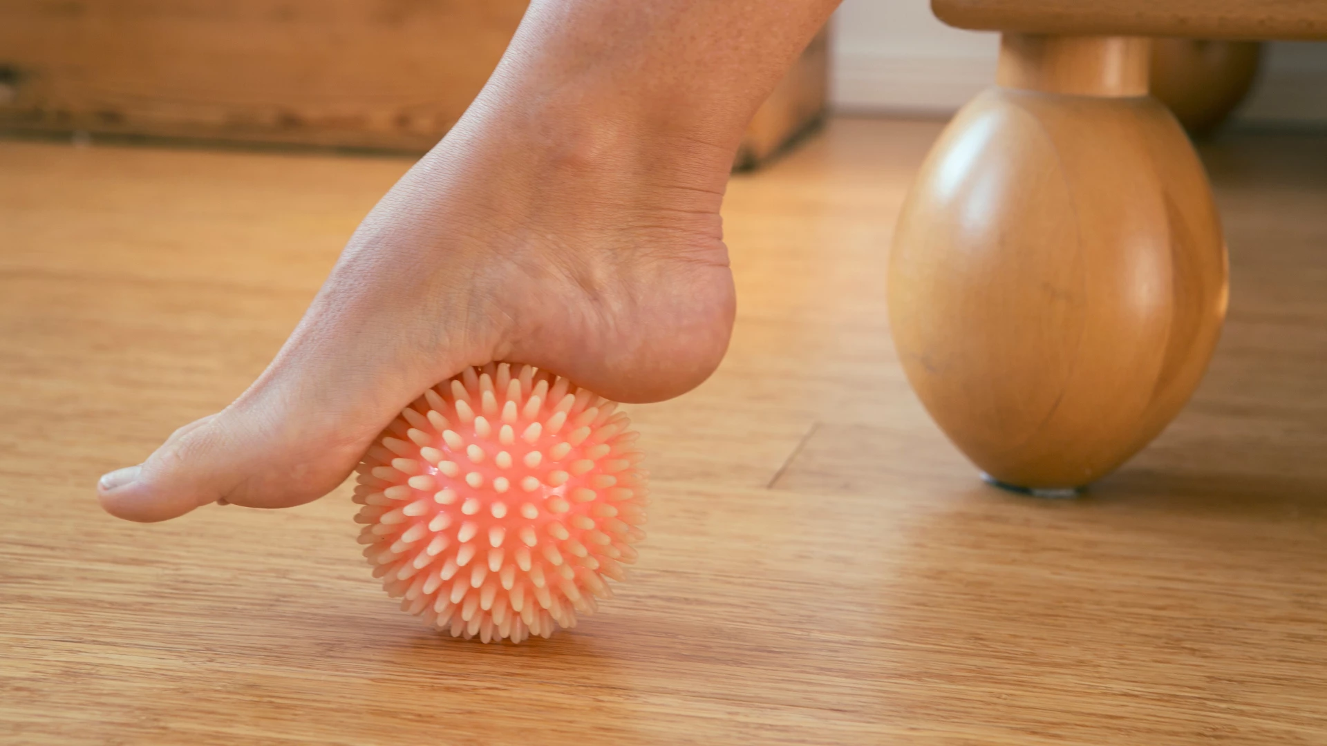 foot with rubber massage ball and showing how the ankles move; improve ankle mobility concept.