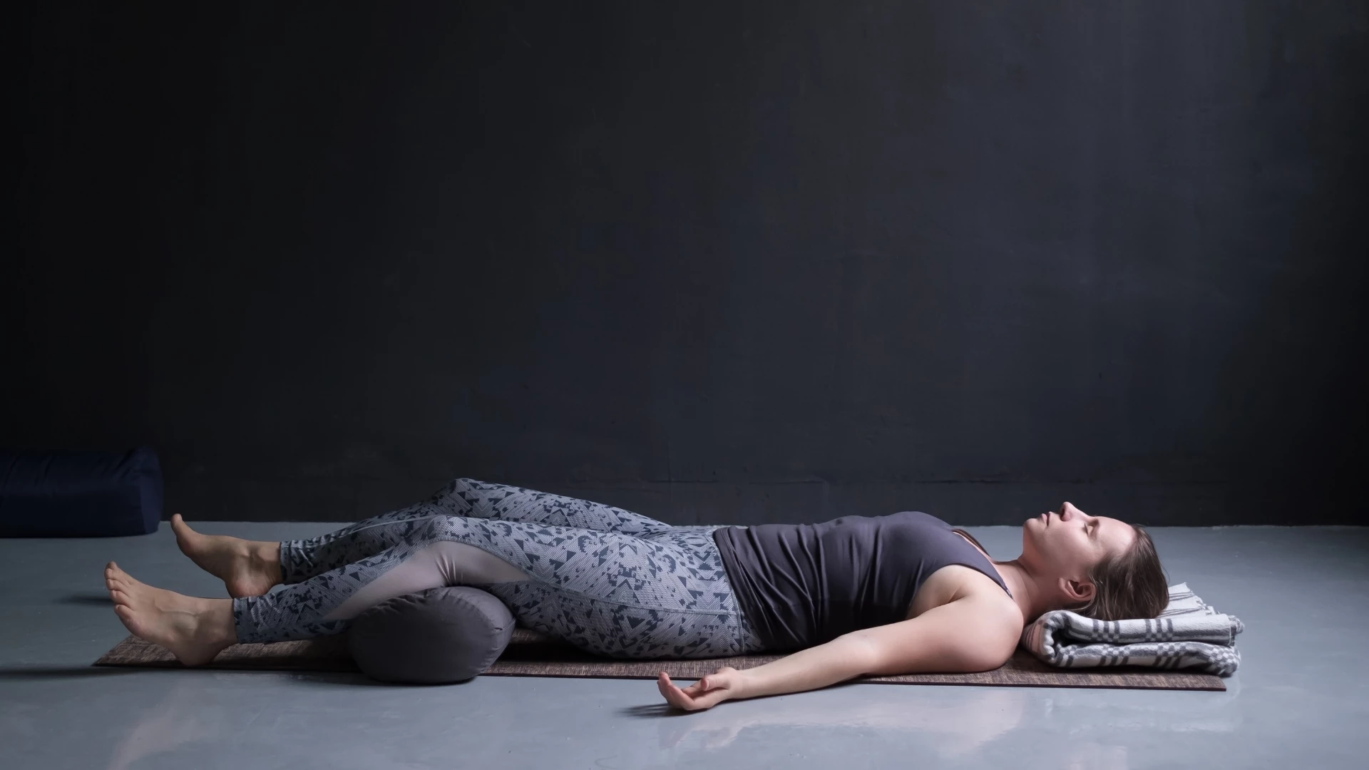 young woman practicing Savasana or Corpse Pose a healing and beneficial practice.