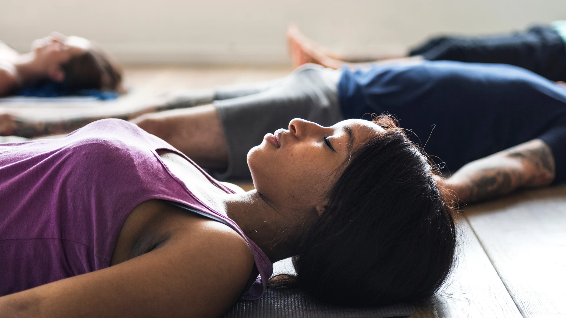 Group of diverse people are joining a yoga class with a calming Savasana like pose.