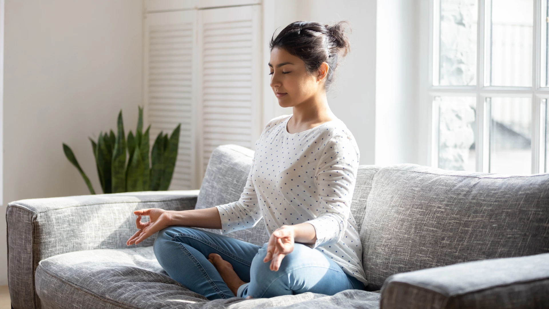 Two young slim girls sit in the lotus positions with closing eyes