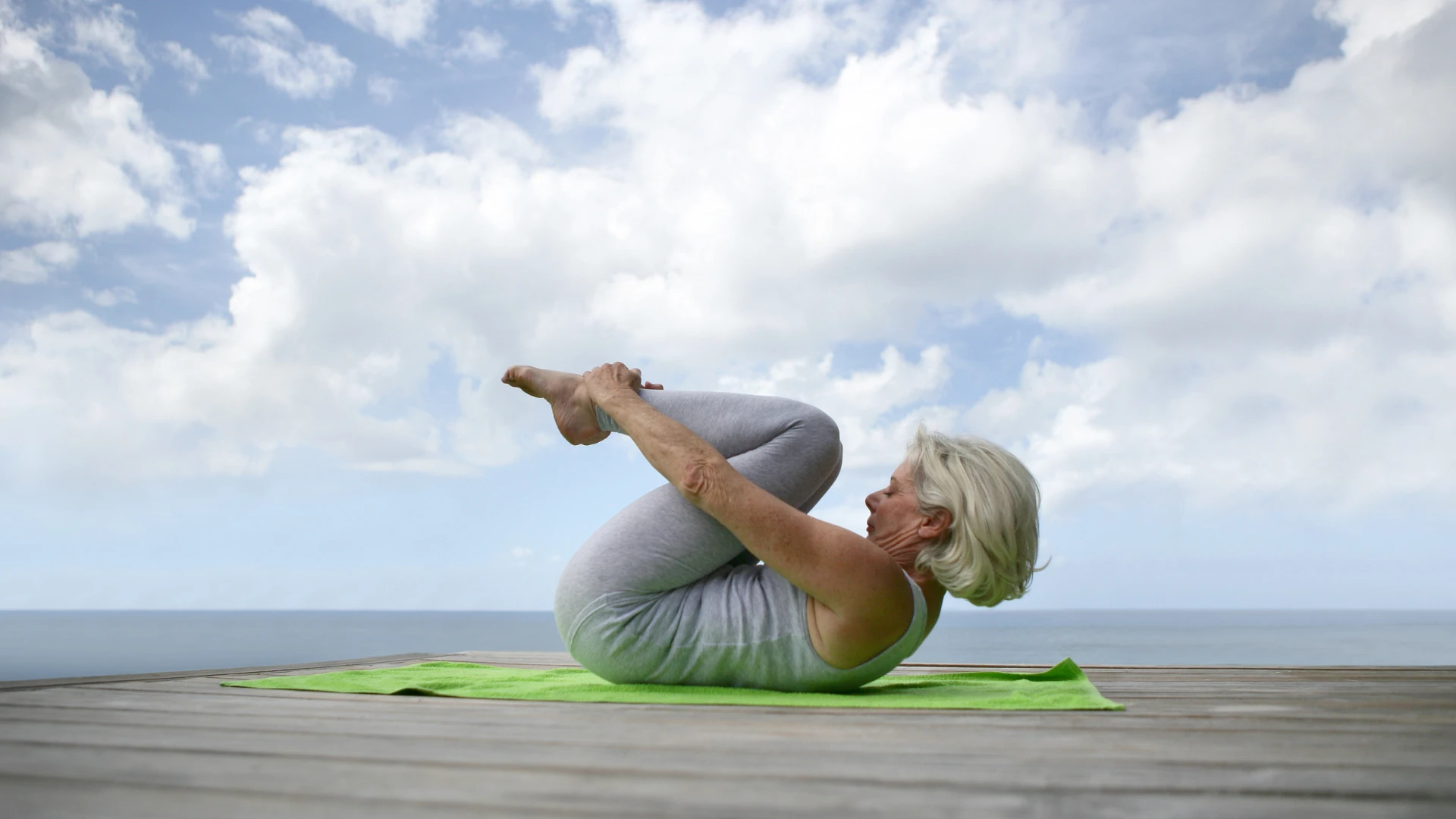 Senior woman practicing yoga pose as question waiting for body response not forcing flexibility